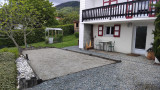 Terrain de boules et coin détente sous balcon.