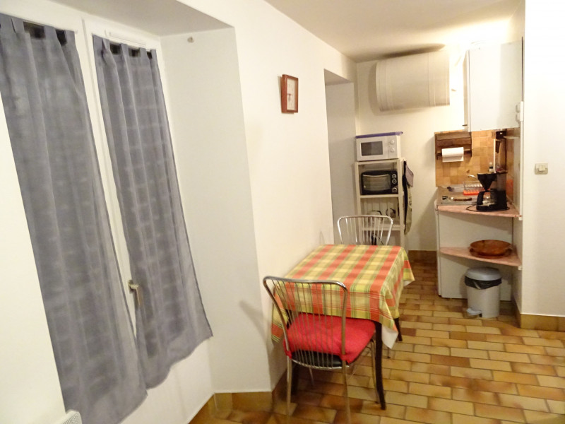 Une cuisine ouverte sur une salle à manger avec une table et des chaises.